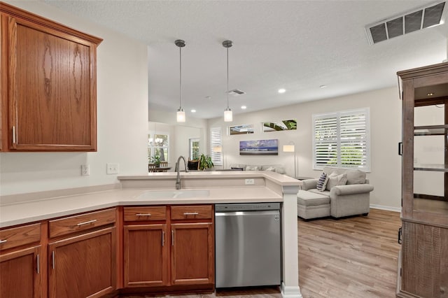 kitchen with kitchen peninsula, pendant lighting, light hardwood / wood-style flooring, stainless steel dishwasher, and sink