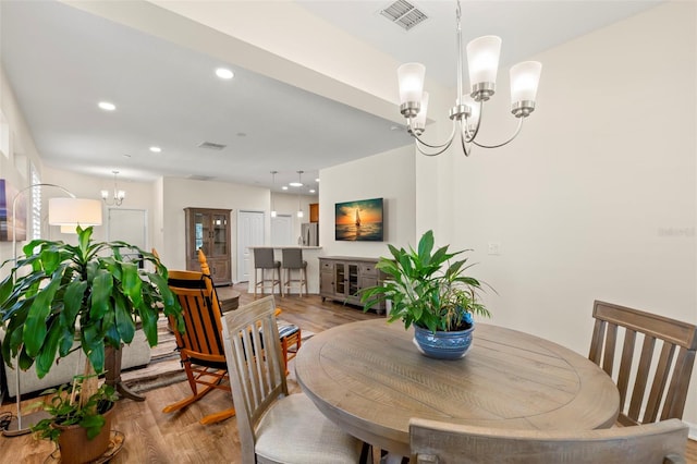 dining room with an inviting chandelier, light hardwood / wood-style flooring, and french doors