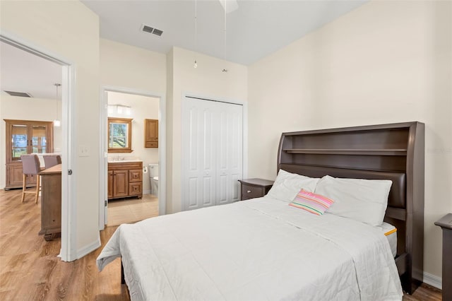 bedroom with light hardwood / wood-style flooring, connected bathroom, a closet, and ceiling fan