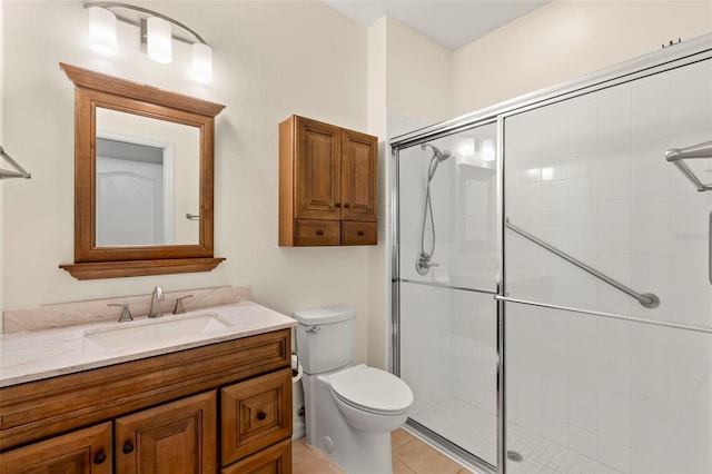 bathroom featuring tile patterned floors, a shower with shower door, vanity, and toilet