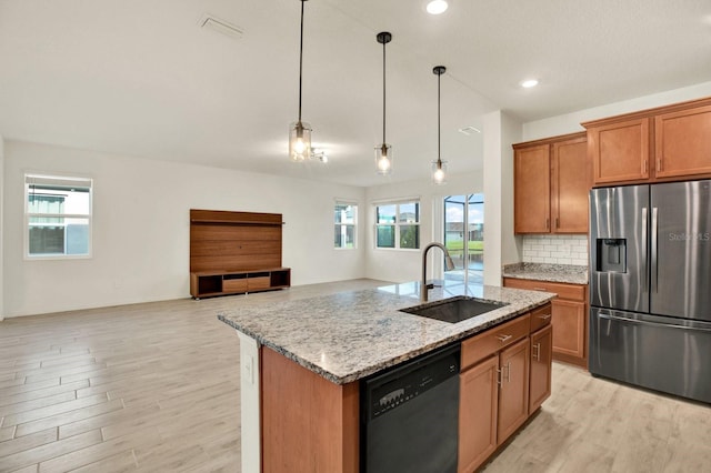 kitchen with stainless steel appliances, a wealth of natural light, decorative light fixtures, and sink