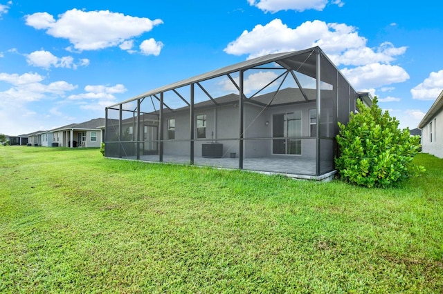 back of house with cooling unit, a lawn, a lanai, and a patio area