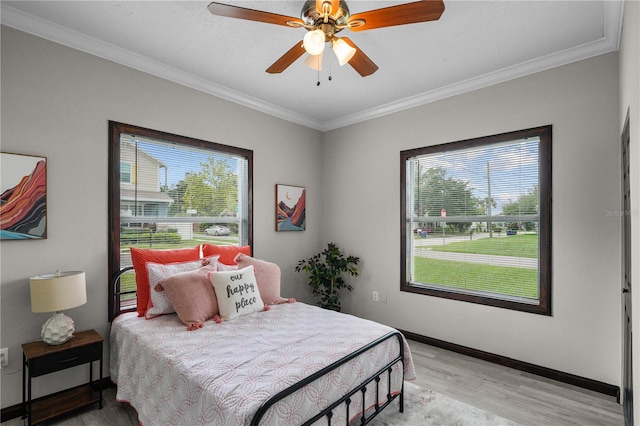 bedroom with multiple windows, ceiling fan, and wood-type flooring