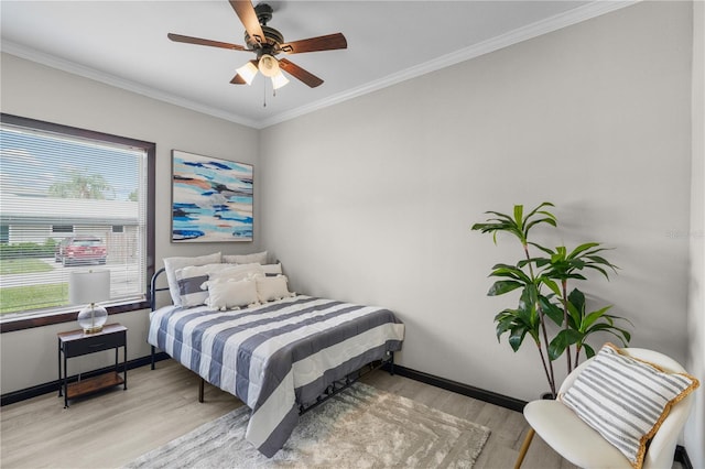 bedroom with light hardwood / wood-style floors, ceiling fan, and crown molding