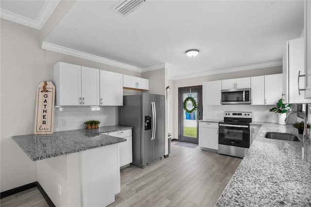 kitchen featuring white cabinets, appliances with stainless steel finishes, stone counters, and sink