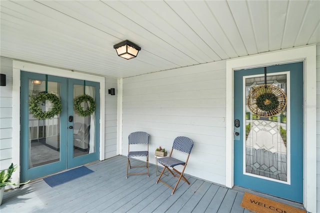 view of exterior entry with covered porch and french doors