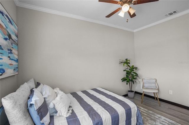 bedroom with wood-type flooring, ceiling fan, and crown molding