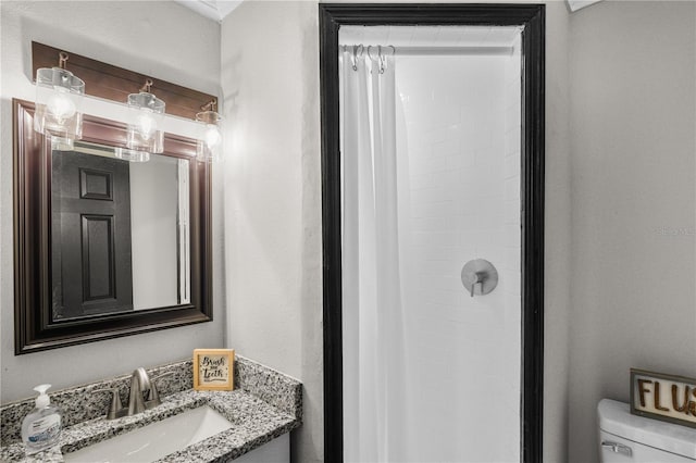 bathroom featuring walk in shower, vanity, and toilet