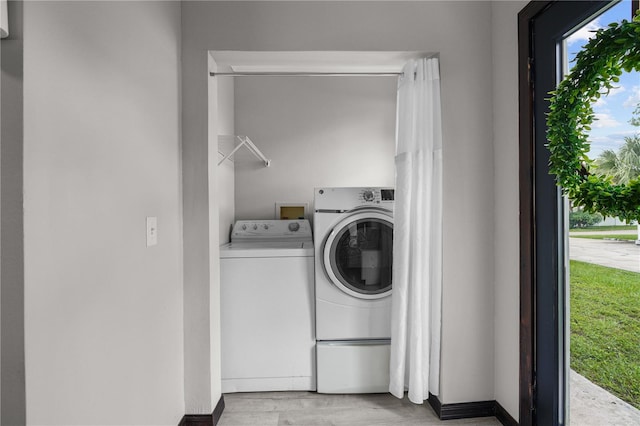 laundry area featuring washing machine and dryer and light hardwood / wood-style flooring