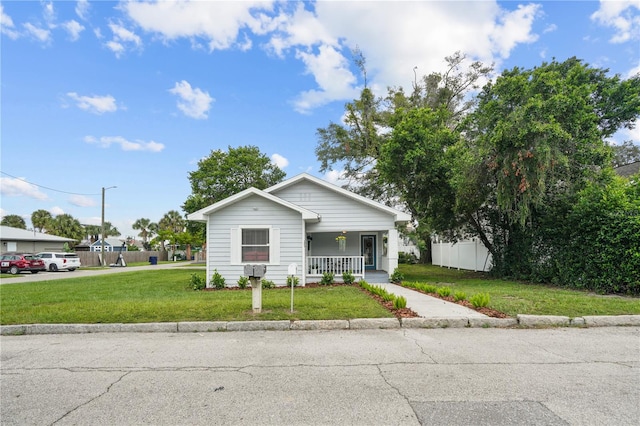 bungalow-style house featuring a porch and a front lawn