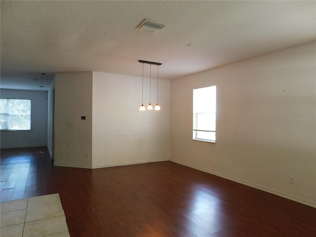 spare room with a textured ceiling and dark wood-type flooring