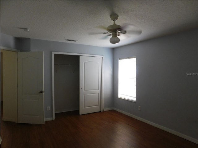 unfurnished bedroom with a textured ceiling, dark hardwood / wood-style floors, ceiling fan, and a closet