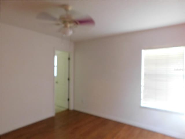 unfurnished room featuring ceiling fan and dark hardwood / wood-style flooring