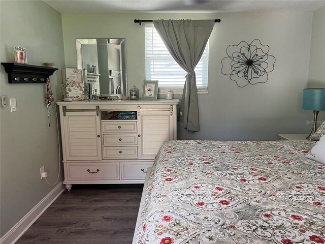 bedroom with dark hardwood / wood-style floors