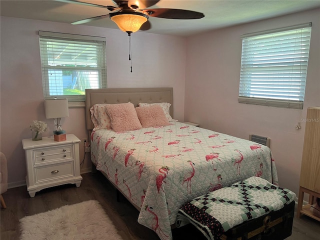 bedroom with ceiling fan, dark hardwood / wood-style floors, and multiple windows