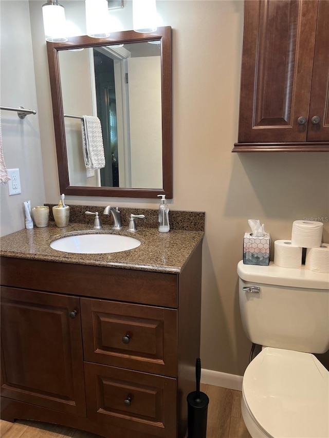 bathroom featuring vanity, hardwood / wood-style floors, and toilet