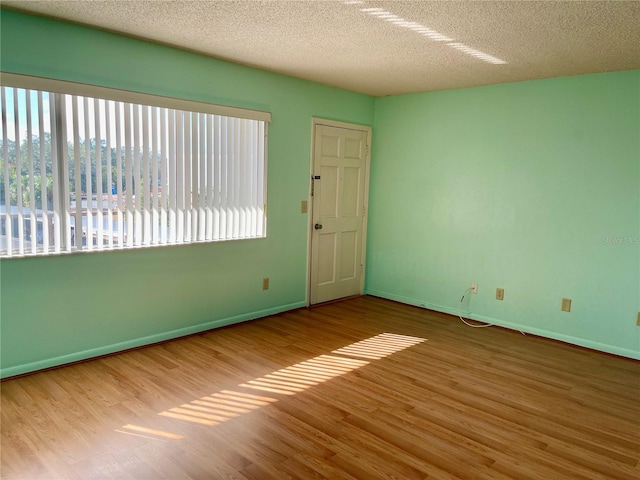 spare room featuring a textured ceiling and hardwood / wood-style flooring