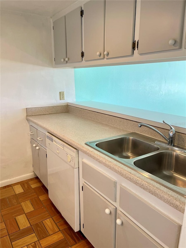 kitchen featuring dark parquet flooring, white dishwasher, and sink