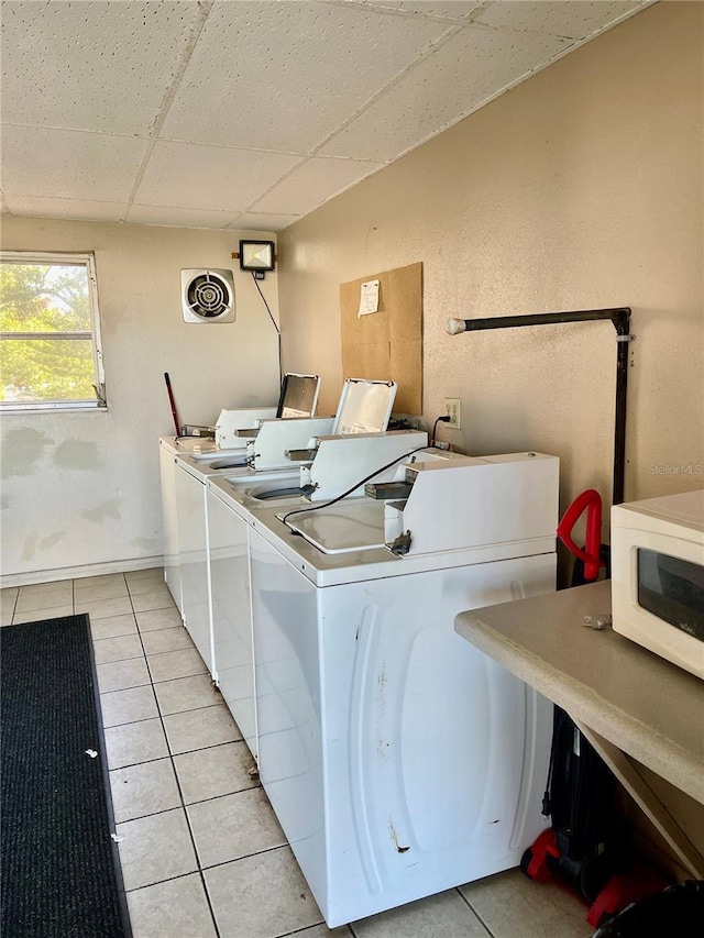 laundry room with washing machine and clothes dryer and light tile patterned flooring