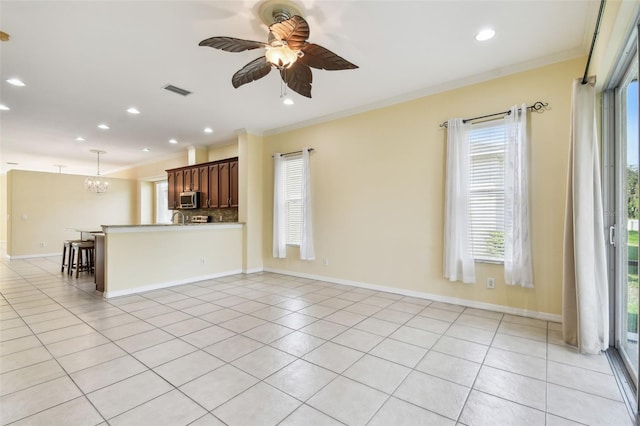 unfurnished living room featuring ceiling fan with notable chandelier, light tile patterned floors, and crown molding