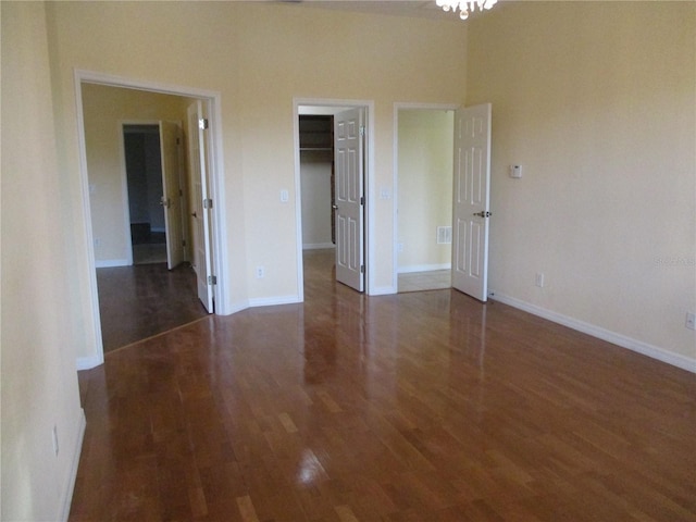 unfurnished bedroom featuring dark hardwood / wood-style floors, a spacious closet, and a closet