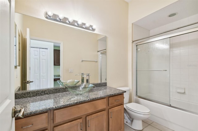 full bathroom with toilet, vanity, tile patterned floors, and combined bath / shower with glass door