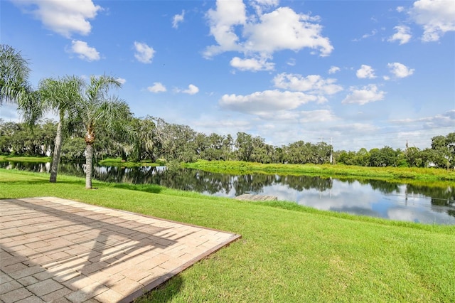 surrounding community with a water view, a patio area, and a lawn