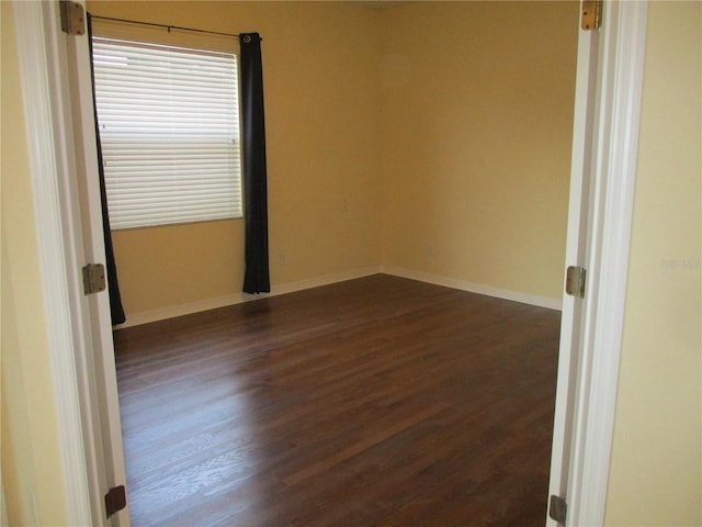 spare room with dark wood-type flooring