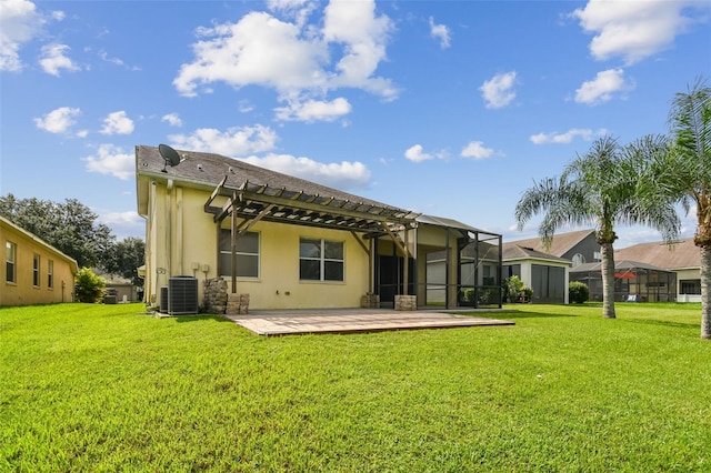 rear view of house with central AC, a yard, a patio, and glass enclosure