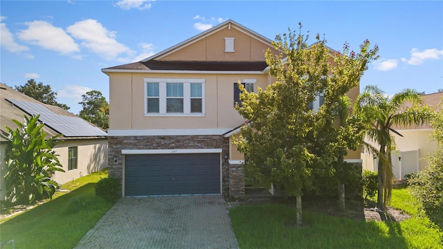 view of front of property featuring stone siding, stucco siding, an attached garage, and decorative driveway