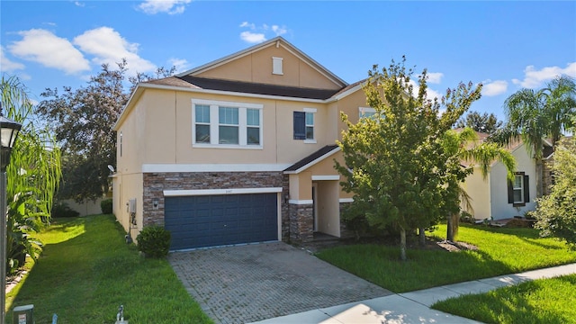 view of front of property featuring stucco siding, decorative driveway, an attached garage, and a front yard