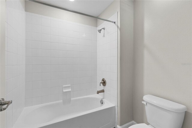 bathroom with toilet and tiled shower / bath combo