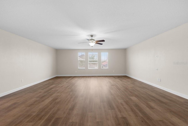 spare room with ceiling fan and dark hardwood / wood-style floors