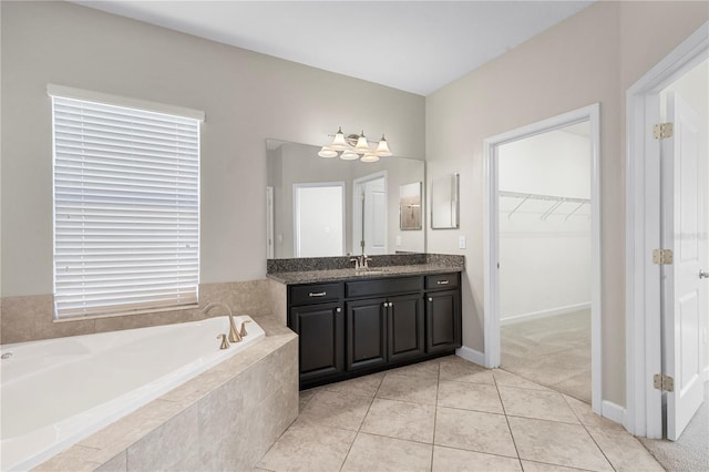 bathroom with tiled bath, vanity, and tile patterned floors