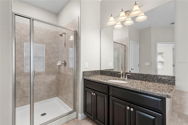 bathroom with tile patterned flooring, walk in shower, and vanity