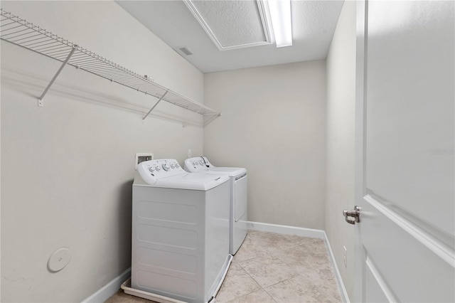 washroom featuring light tile patterned floors and washer and clothes dryer