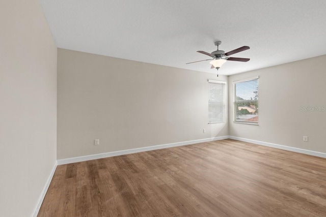 spare room with a textured ceiling, ceiling fan, and light hardwood / wood-style flooring