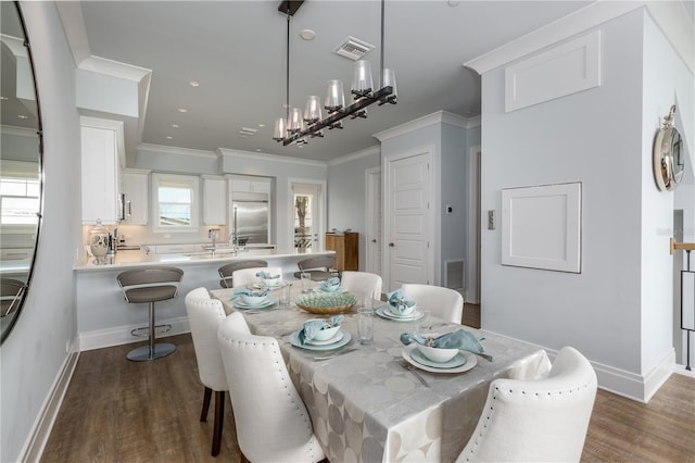 dining room with crown molding, dark hardwood / wood-style flooring, sink, and a wealth of natural light