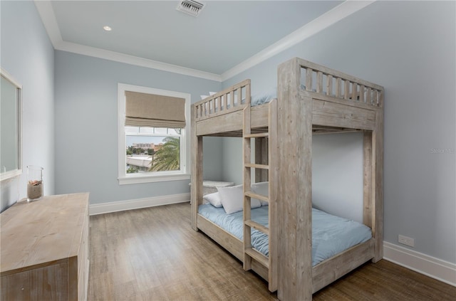 bedroom featuring ornamental molding and hardwood / wood-style floors