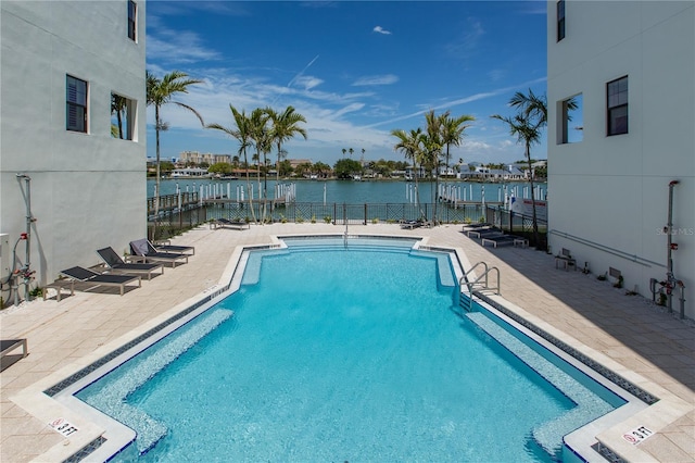 view of pool with a patio and a water view