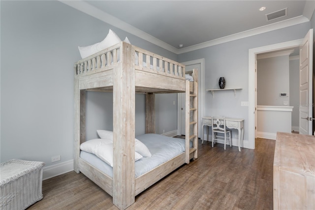 bedroom with ornamental molding and dark hardwood / wood-style flooring