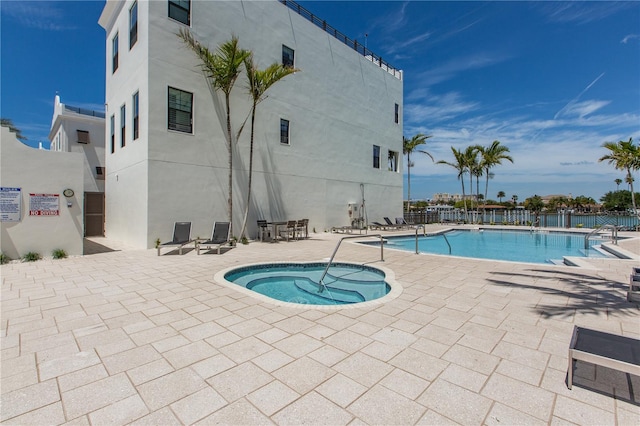 view of pool featuring a community hot tub and a patio area