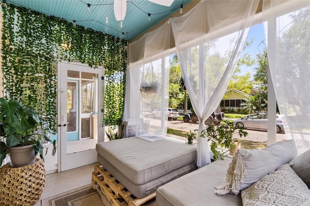 sunroom with lofted ceiling, ceiling fan, and a wealth of natural light