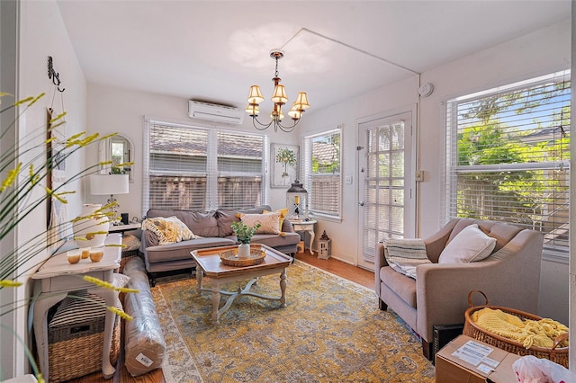 living room featuring a notable chandelier, an AC wall unit, and hardwood / wood-style flooring