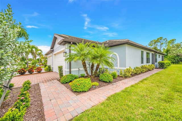 view of side of property with a lawn and a garage