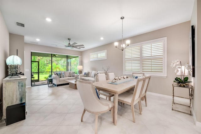 tiled dining room with ceiling fan with notable chandelier