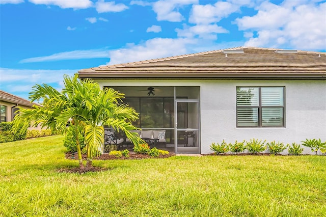 back of property with a sunroom and a yard