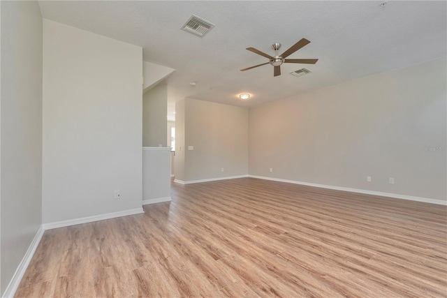 empty room with ceiling fan, light hardwood / wood-style floors, and a textured ceiling