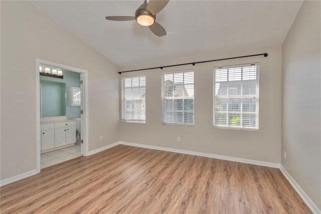 empty room featuring light wood-type flooring, vaulted ceiling, and ceiling fan