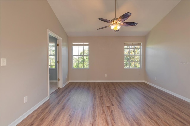 unfurnished room featuring hardwood / wood-style flooring, vaulted ceiling, ceiling fan, and a healthy amount of sunlight